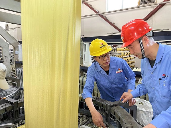 1653620936533051.jpeg 圓織機(jī)技術(shù)升級(jí)改造攻關(guān)組在現(xiàn)場(chǎng)研究圓織機(jī)潤(rùn)滑技術(shù)照片.jpg