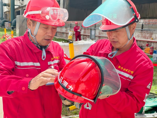 141744595056281756.jpg 團(tuán)結(jié)協(xié)作 施工人員正在為其工友安裝安全面罩.jpg